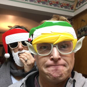 Kat and I with Christmas masks. Kat is eating a cookie. It's 2016.