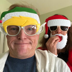 Kat and I with Christmas masks. Kat is eating a cookie. It's 2017.